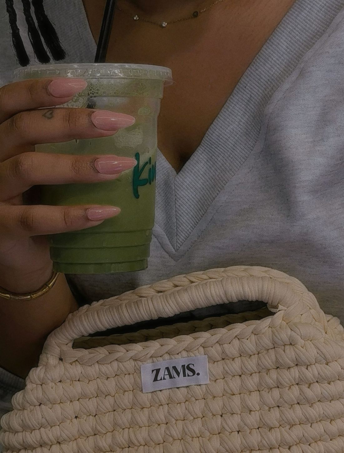 Un sac ZAMS. crème crocheté, porté avec un matcha glacé